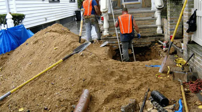 Contractors performing foundation protection and exterior drainage excavation near residential home steps in Louisville, KY